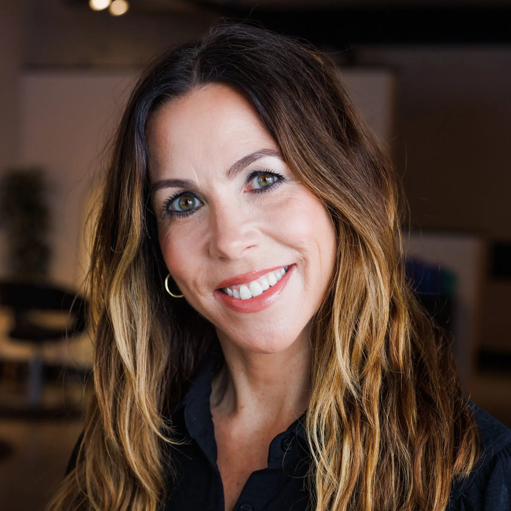 Smiling woman in a dimly lit room