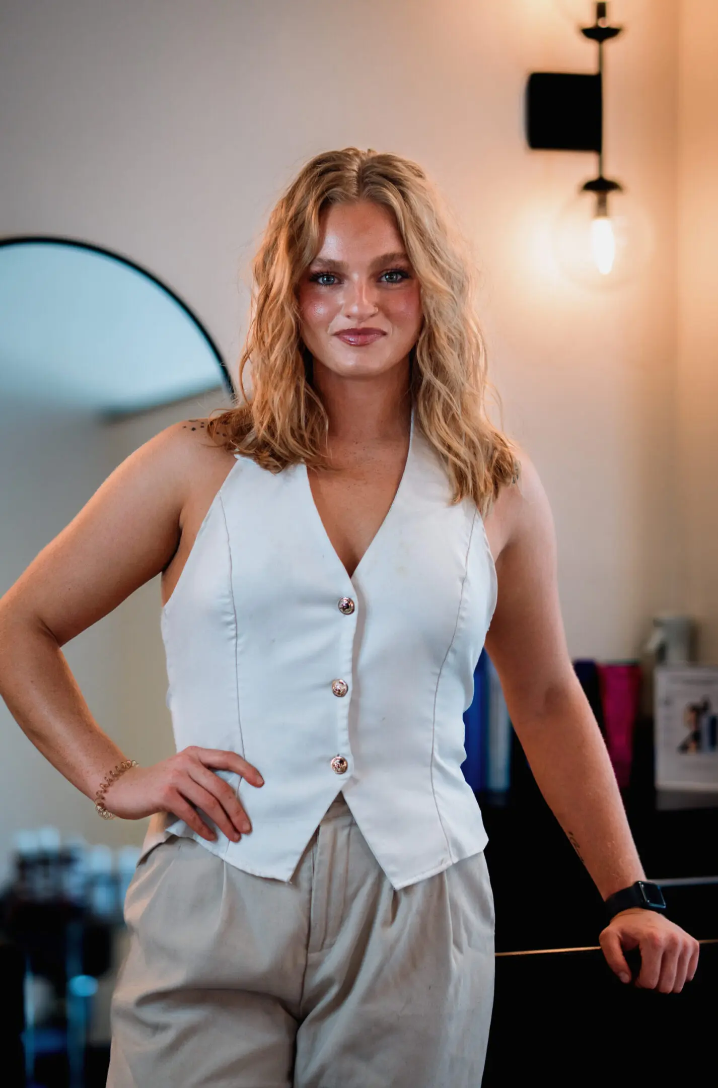 Woman in white vest posing confidently