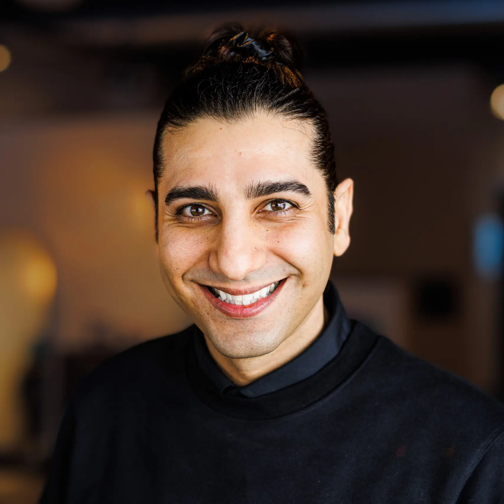 Smiling person with dark hair indoors