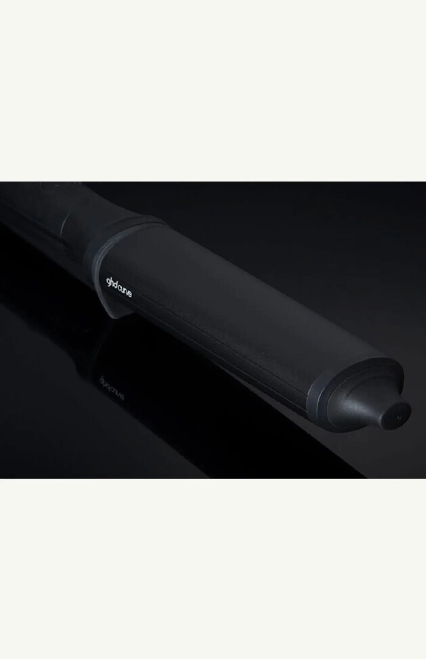 Black curling iron on dark background